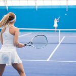 Two girls playing tennis in court